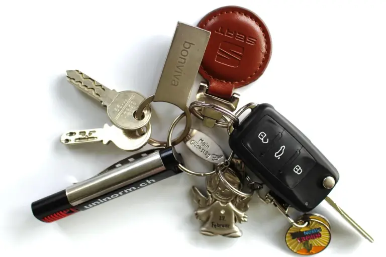 Set of house and car keys with a key fob on a white background, illustrating access control for secure Amazon Garage Delivery.