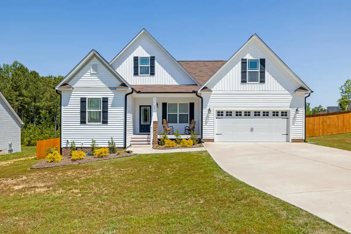 Front exterior of a suburban house with a two-car garage and a wide driveway.