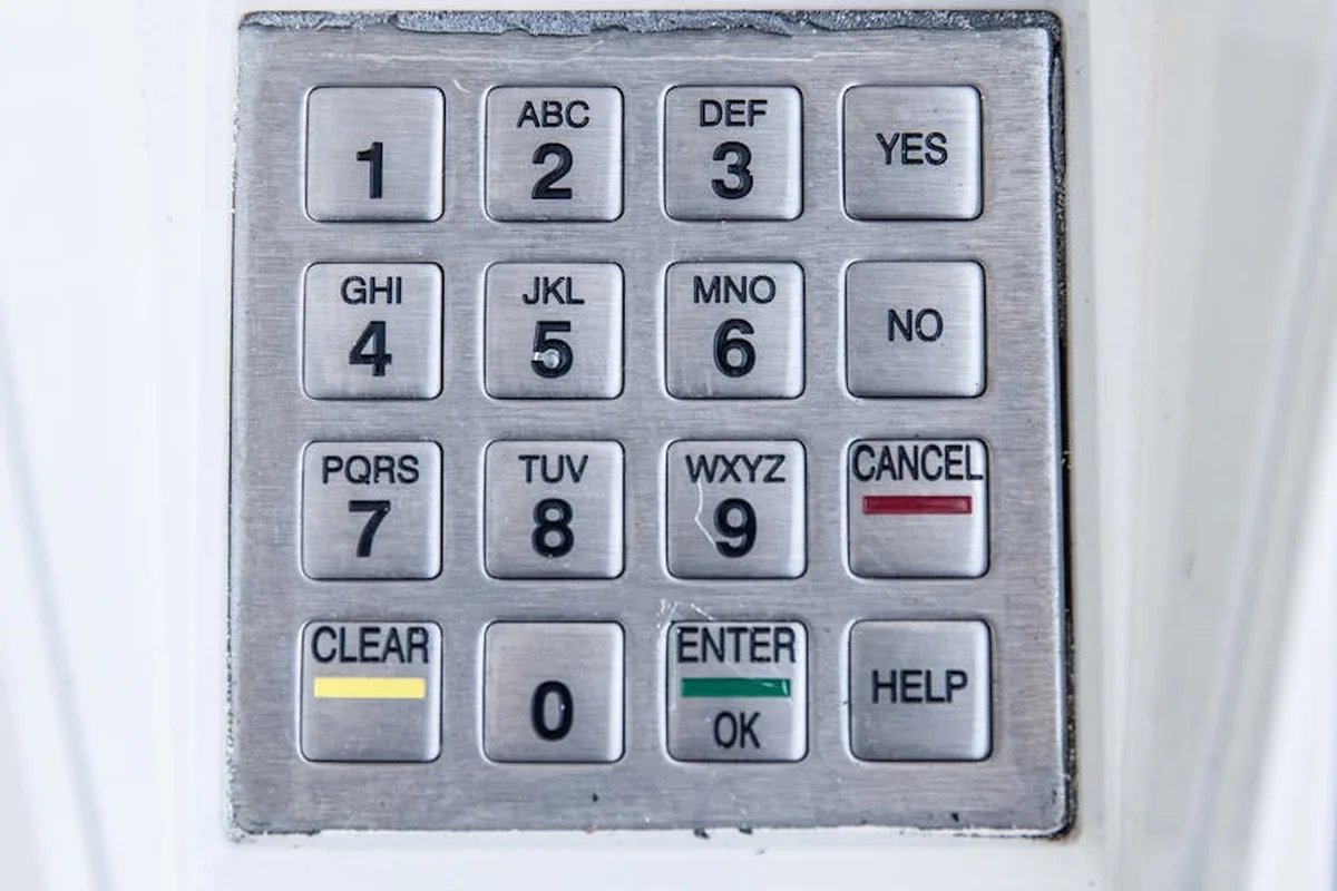 Close-up of a gray garage door keypad with numbered buttons and function keys