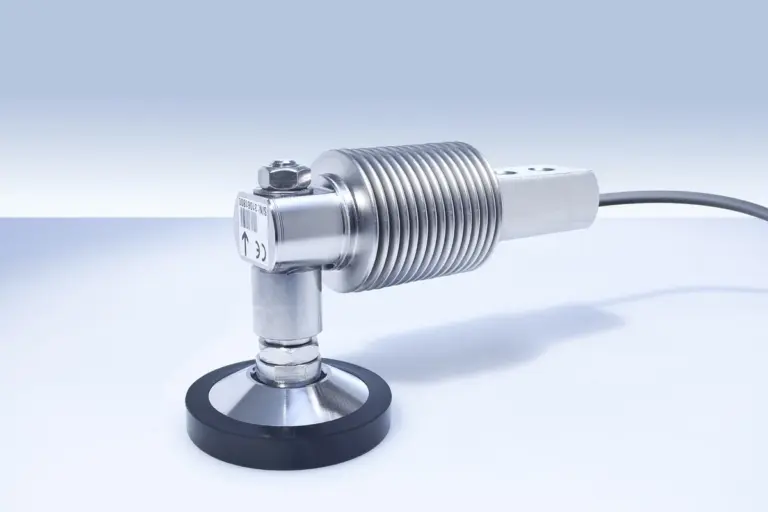 Close-up of a metal threaded sensor mounted on a stand with a black base, illustrating sensor mounting and wiring for garage door safety sensor alignment.