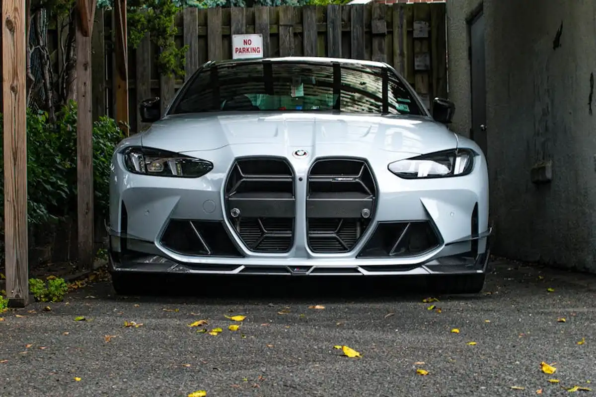 Front view of a silver car parked in a driveway in front of a closed garage.