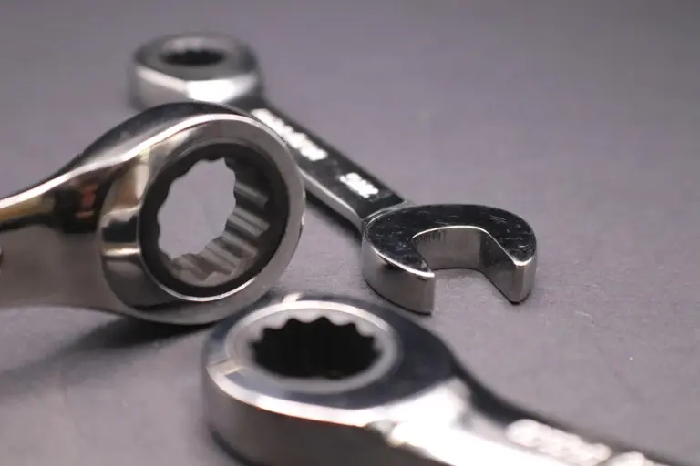Close-up of metal wrenches and a socket on a gray surface, ready for garage door repair.