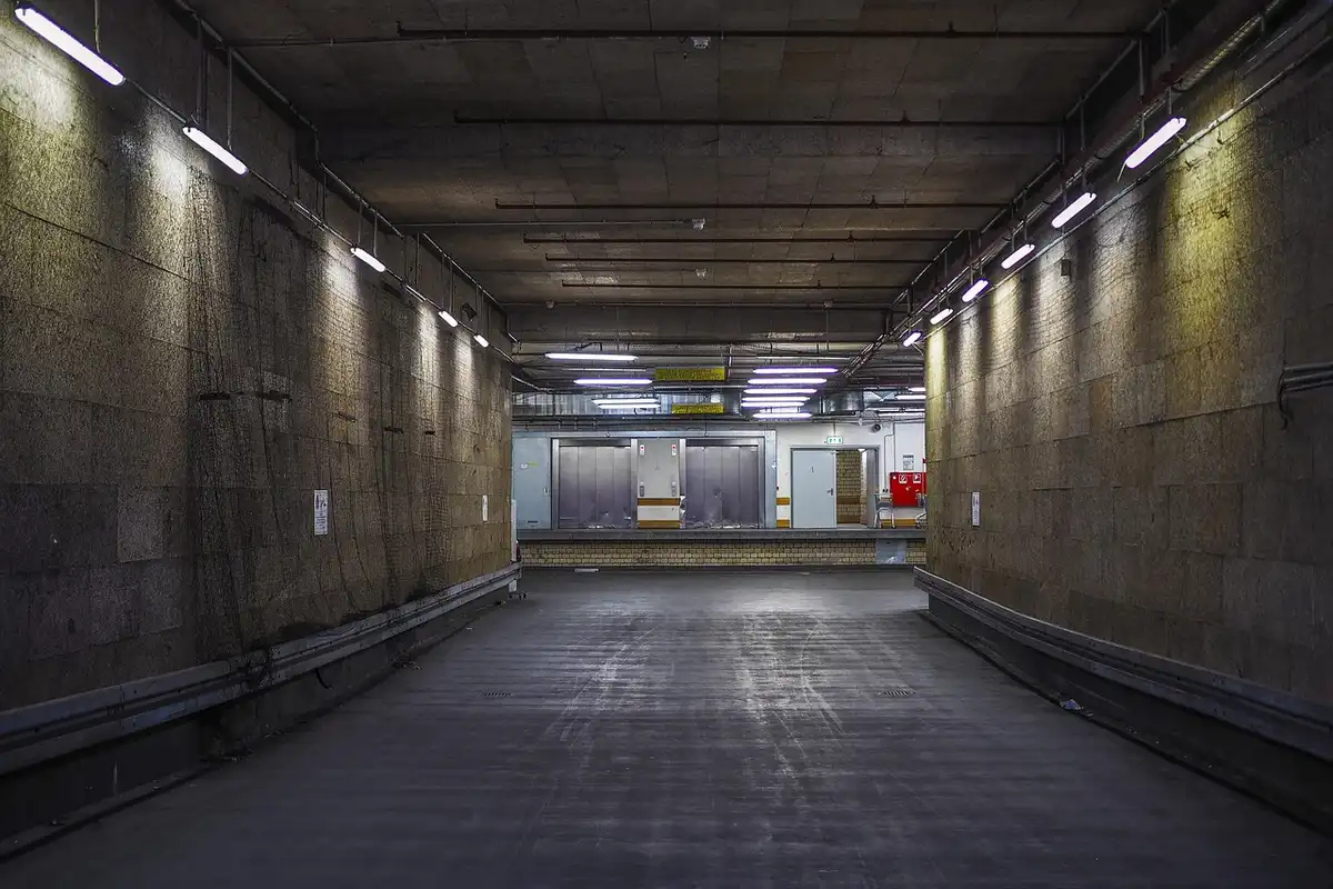 Long, empty concrete garage floor with overhead lighting