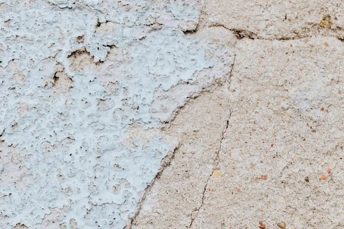 Close-up of fine hairline cracks on a textured garage ceiling or floor surface