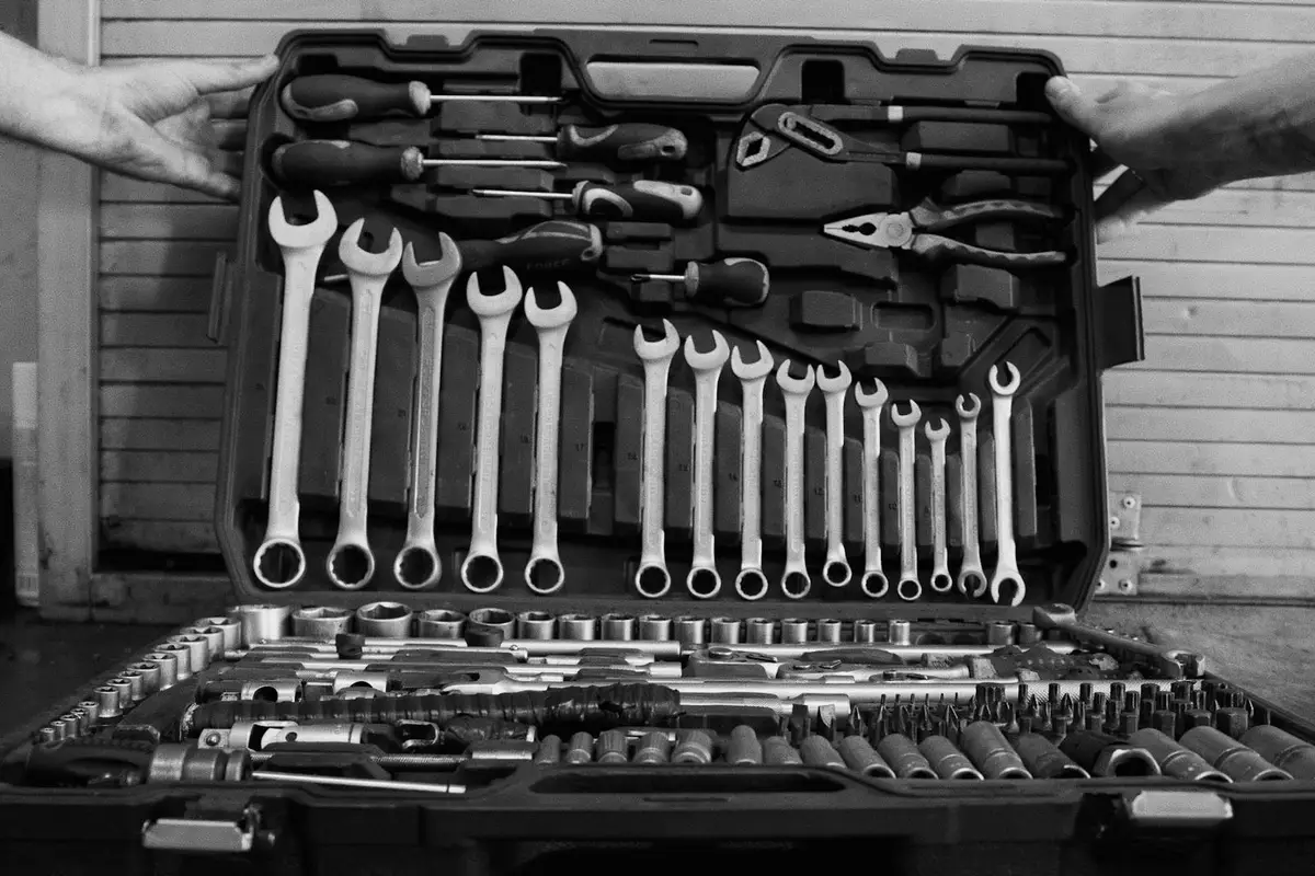 Open toolbox displaying a variety of wrenches, sockets, and pliers for garage door opener installation