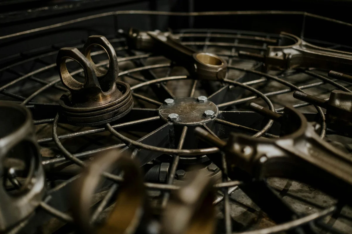 Close-up of a metal wheel with spokes and clamps in a workshop, highlighting tight spaces and gaps