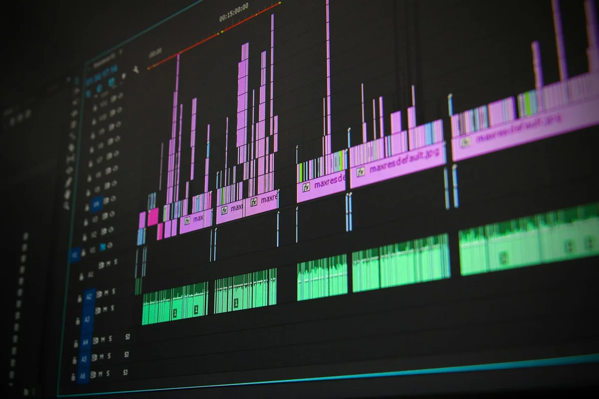 DAW interface on a computer screen with multiple colorful audio tracks and waveform blocks, illustrating soundproofing and acoustics planning for a garage studio.