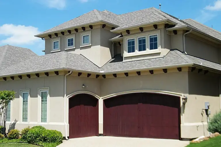 Suburban house with a two-car garage featuring dark maroon wooden doors.
