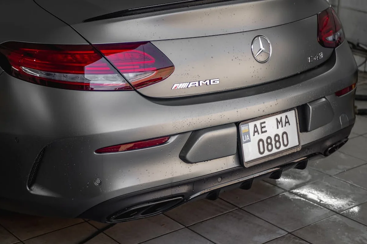 Rear view of a gray Mercedes-Benz AMG parked in a tiled garage, illustrating a space where durable flooring options like interlocking garage tiles and epoxy coatings are evaluated.
