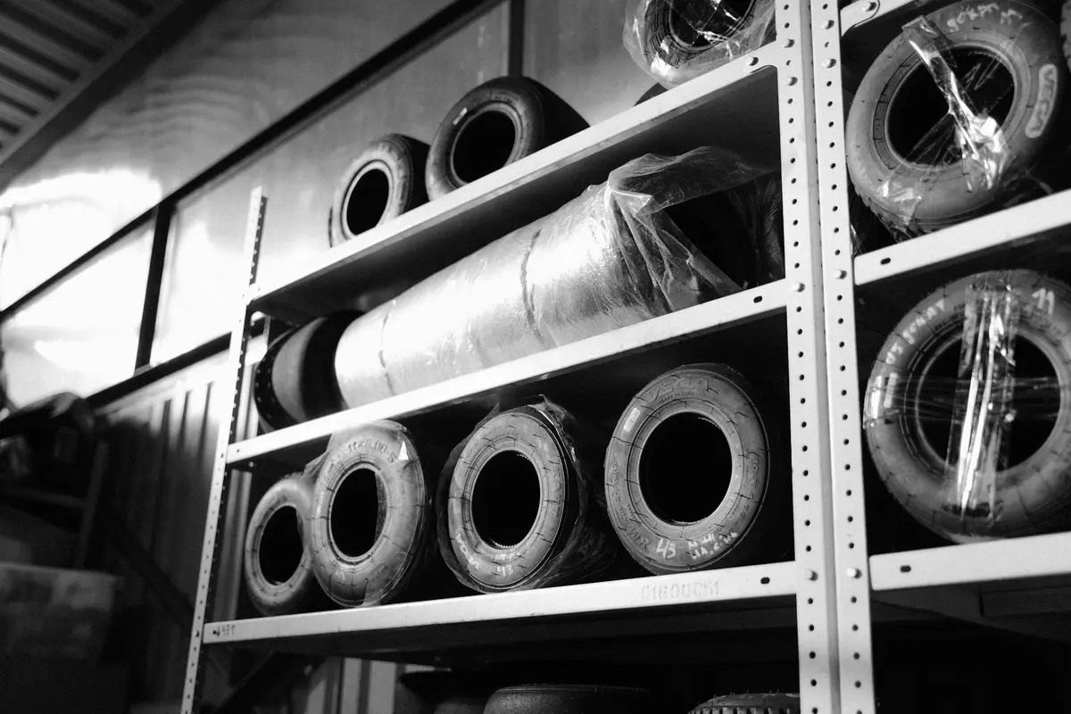 Tires neatly stacked on metal shelving in a garage.