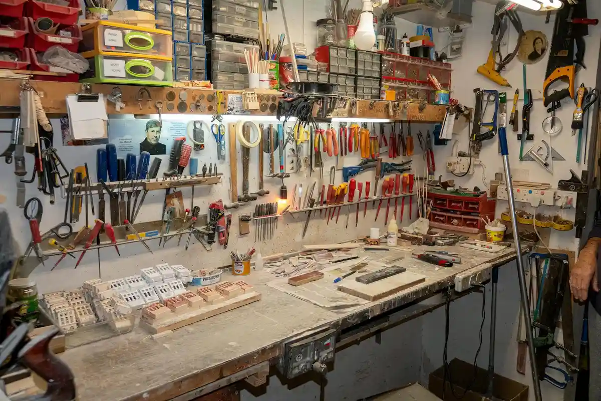 Well-organized garage workbench with a pegboard full of tools and shelves storing hardware, illustrating safe tool storage.