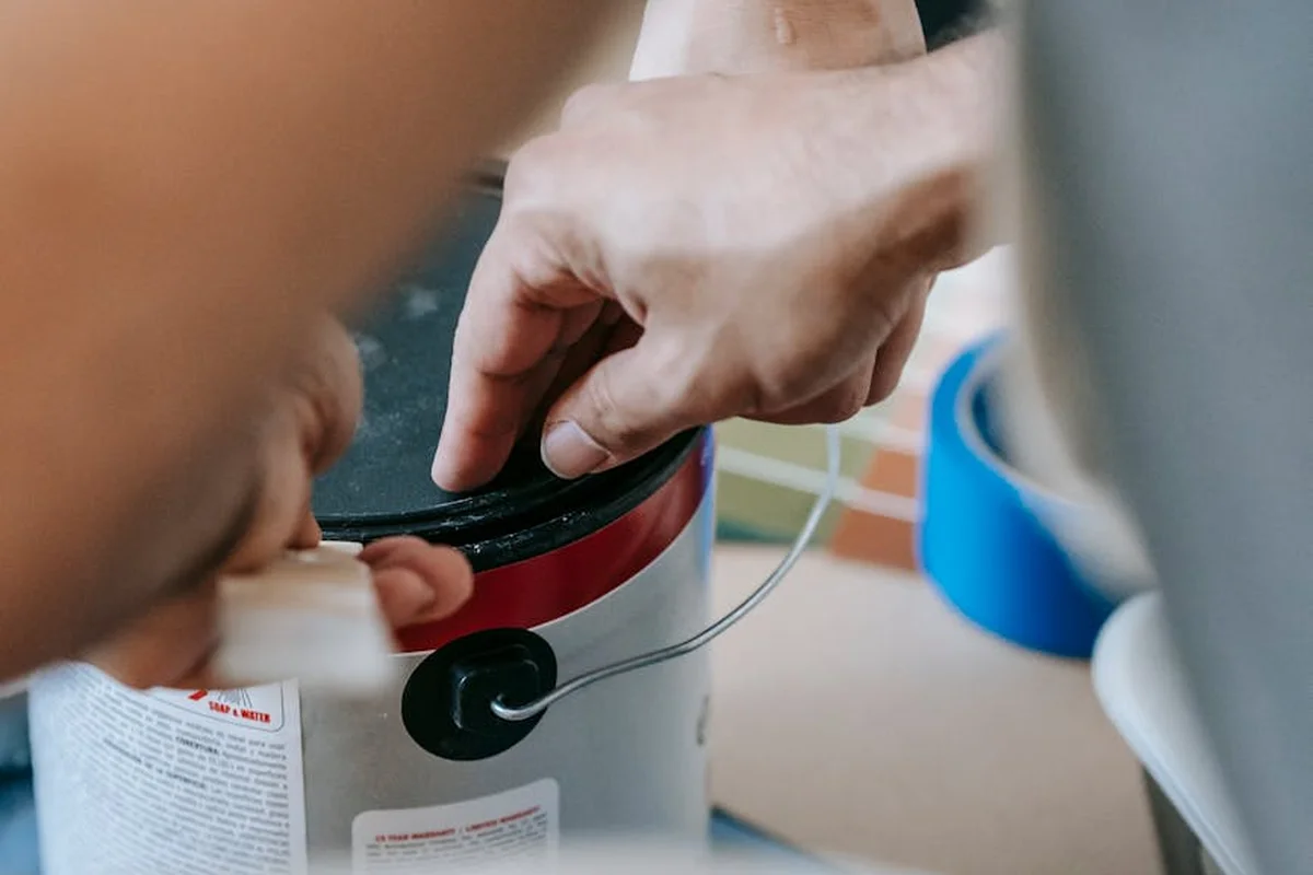 Hands securing a gasoline container in a garage