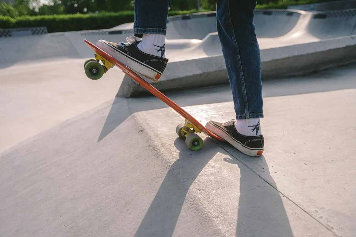 Person on a skateboard riding up a concrete garage ramp, highlighting an inclined surface and edge related to interior access and safety features.