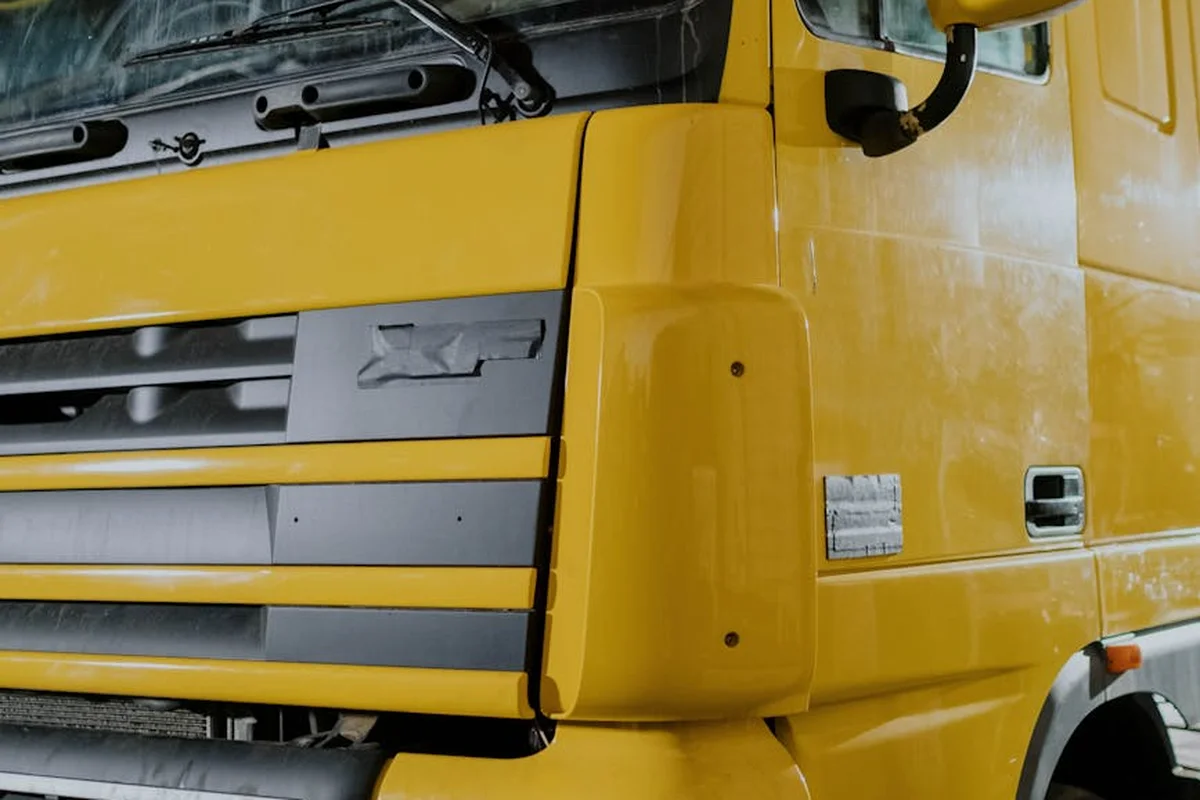 Close-up of a yellow truck in a garage, highlighting the front cab as part of long-term storage prep.