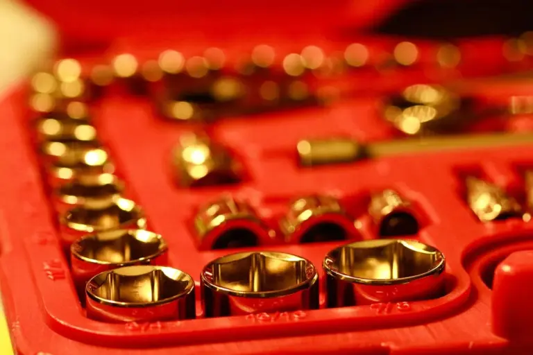 Close-up of a red tool case filled with sockets and bits, representing the hardware used in installing a metal garage door.