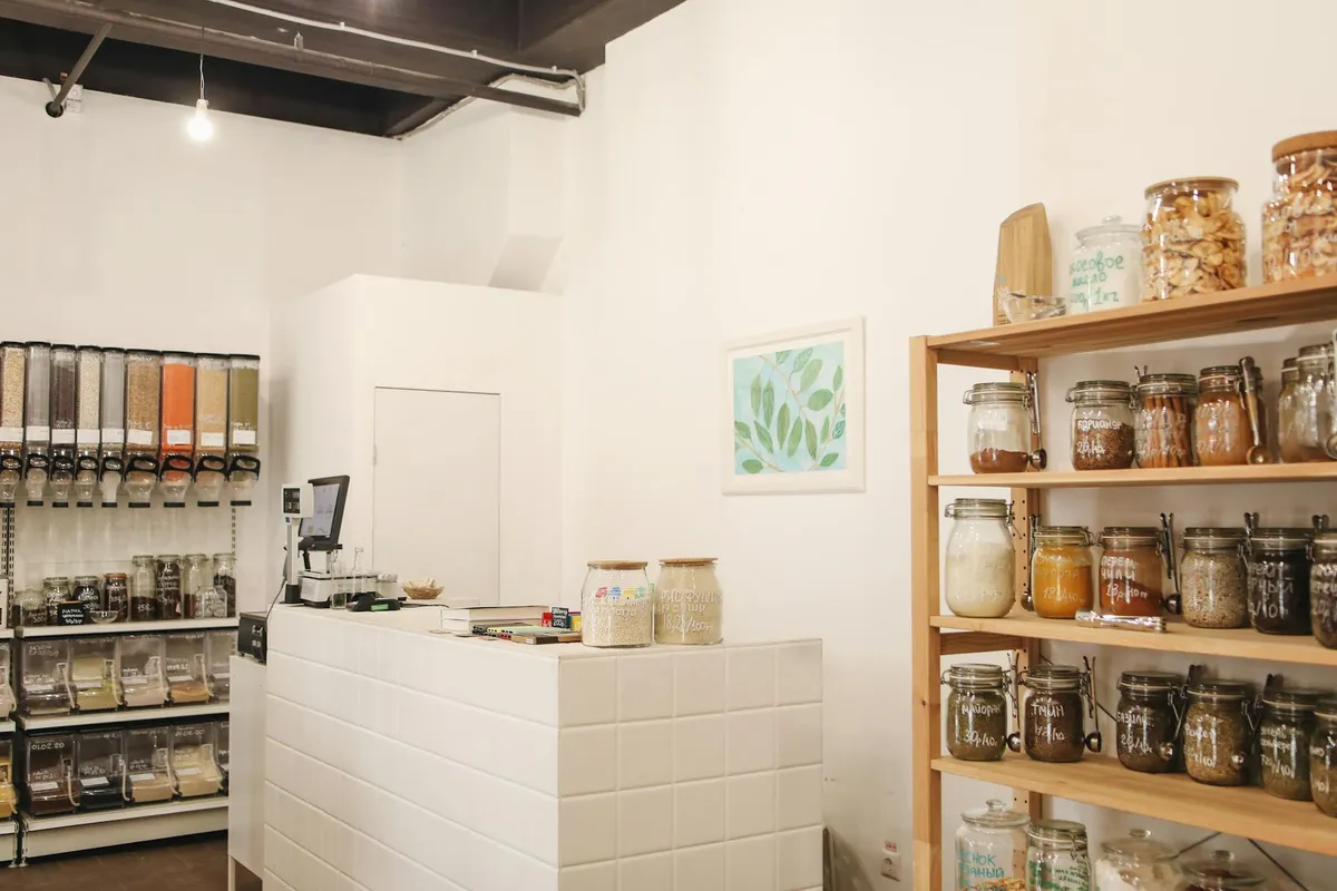 Interior workshop with a white counter and wooden wall shelves filled with jars and containers, illustrating organized storage for a garage shelving project.