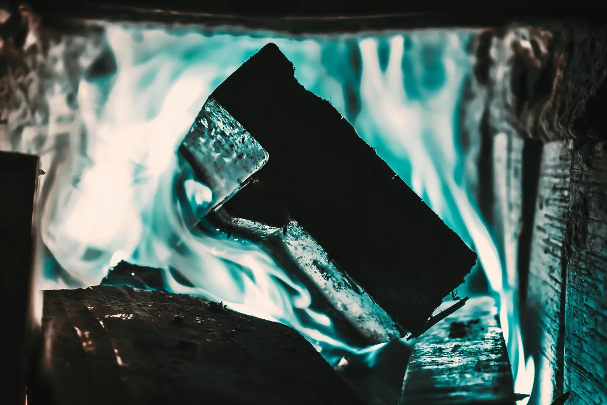 Blue-tinted flames burning logs in a fireplace