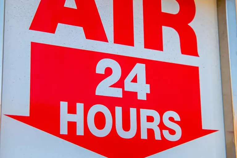 Red sign reading 'AIR 24 HOURS' mounted on a wall