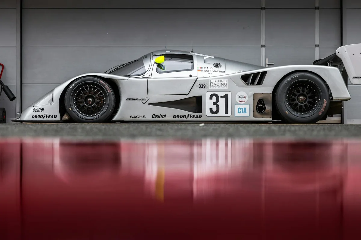 Silver race car with the number 31 parked inside a garage