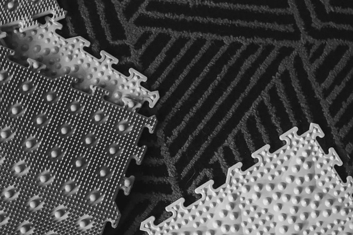 Close-up of interlocking garage floor mats with raised studs and a textured surface