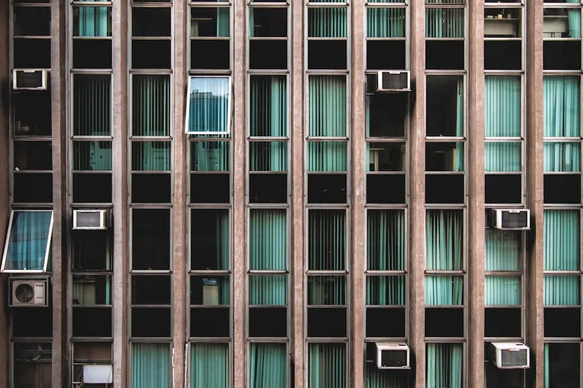 Facade with numerous window air conditioning units installed in many windows.