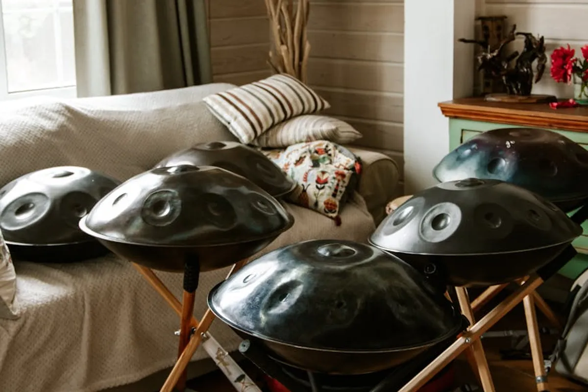 Several handpan drums on stands arranged in a living room, illustrating a gear-heavy music setup.