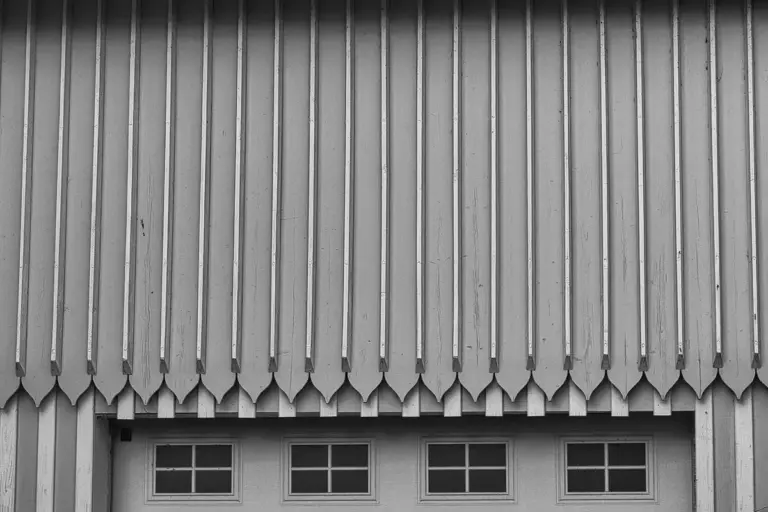 Front view of a garage featuring vertical metal siding and a paneled garage door