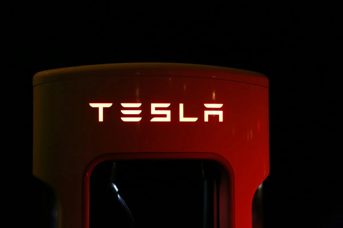 Tesla electric vehicle charger unit glowing red in the dark