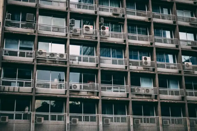 Rows of window air conditioning units installed in a multi-story building facade